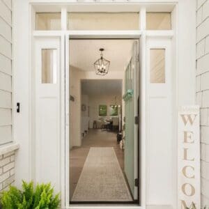 A welcome sign is hanging on the side of a door.