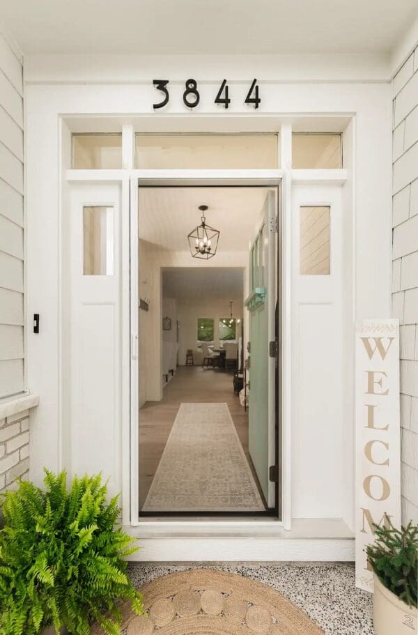 A welcome sign is hanging on the side of a door.