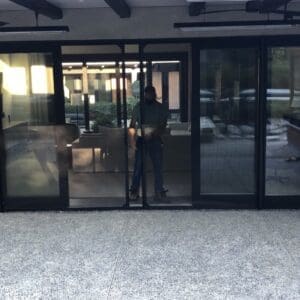 A person standing in front of a glass door.